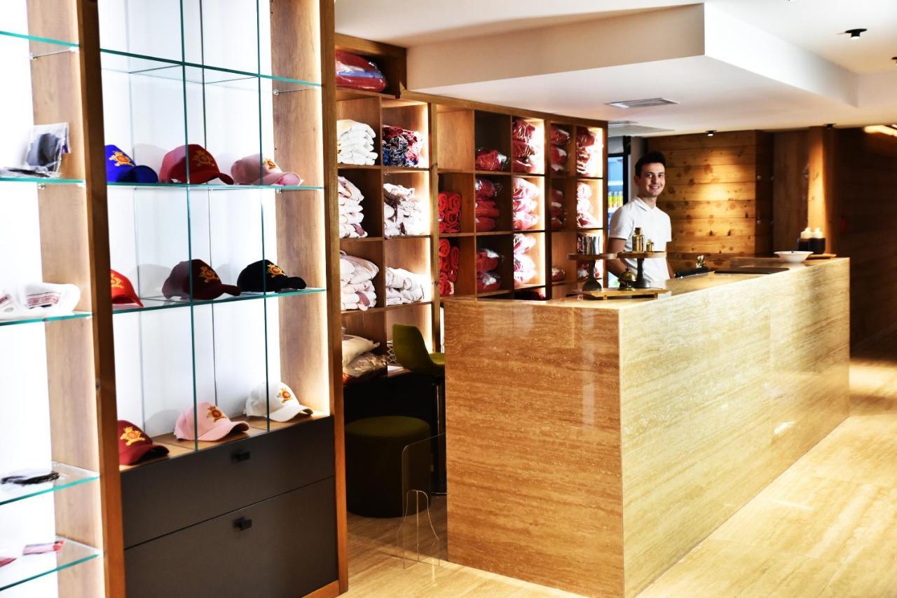 ดอสโซ่ ดอสซี่ โฮเต็ล แอน์ สปา ดาวน์ทาวน์ Hotel อิสตันบูล ภายนอก รูปภาพ The photo shows a retail space or reception area with a warm and modern design. On the left, there are shelves displaying various colorful caps, neatly arranged behind glass. The right side features a wooden counter where a staff member is standing, 