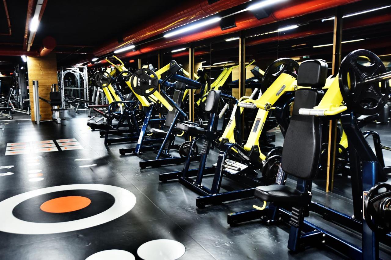 ดอสโซ่ ดอสซี่ โฮเต็ล แอน์ สปา ดาวน์ทาวน์ Hotel อิสตันบูล ภายนอก รูปภาพ The photo shows a modern gym interior featuring various exercise machines. There are several yellow and black weight training machines aligned in rows, with a focus on strength training equipment. The flooring is dark with circular patterns, includin