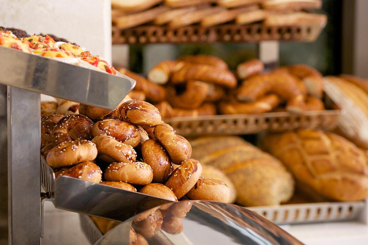 ดอสโซ่ ดอสซี่ โฮเต็ล แอน์ สปา ดาวน์ทาวน์ Hotel อิสตันบูล ภายนอก รูปภาพ The photo shows a display of various types of baked goods. In the foreground, there are small, round bread rolls topped with sesame seeds. Behind them, multiple trays are stacked with an assortment of different breads, including twisted rolls and loa