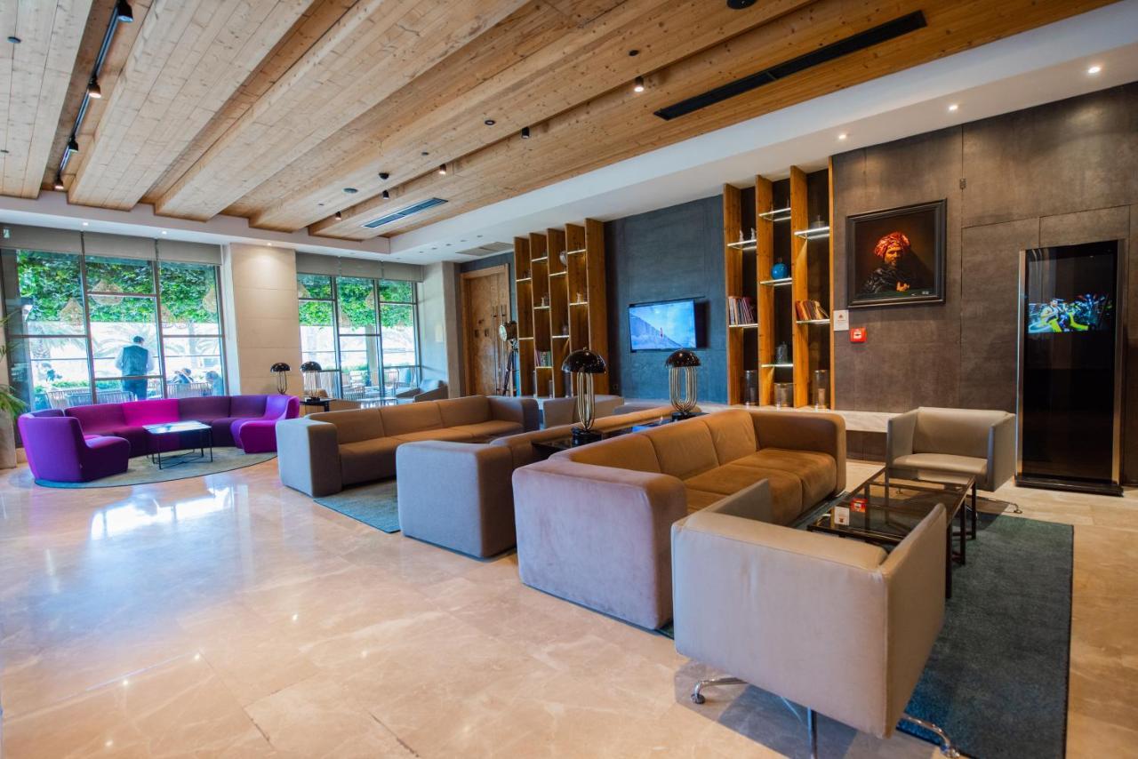 ดอสโซ่ ดอสซี่ โฮเต็ล แอน์ สปา ดาวน์ทาวน์ Hotel อิสตันบูล ภายนอก รูปภาพ The photo shows a modern and stylish lobby area, featuring a combination of seating options. The space includes two large sofas in neutral colors, arranged around small glass tables. There are also individual armchairs and a more vibrant purple sofa 