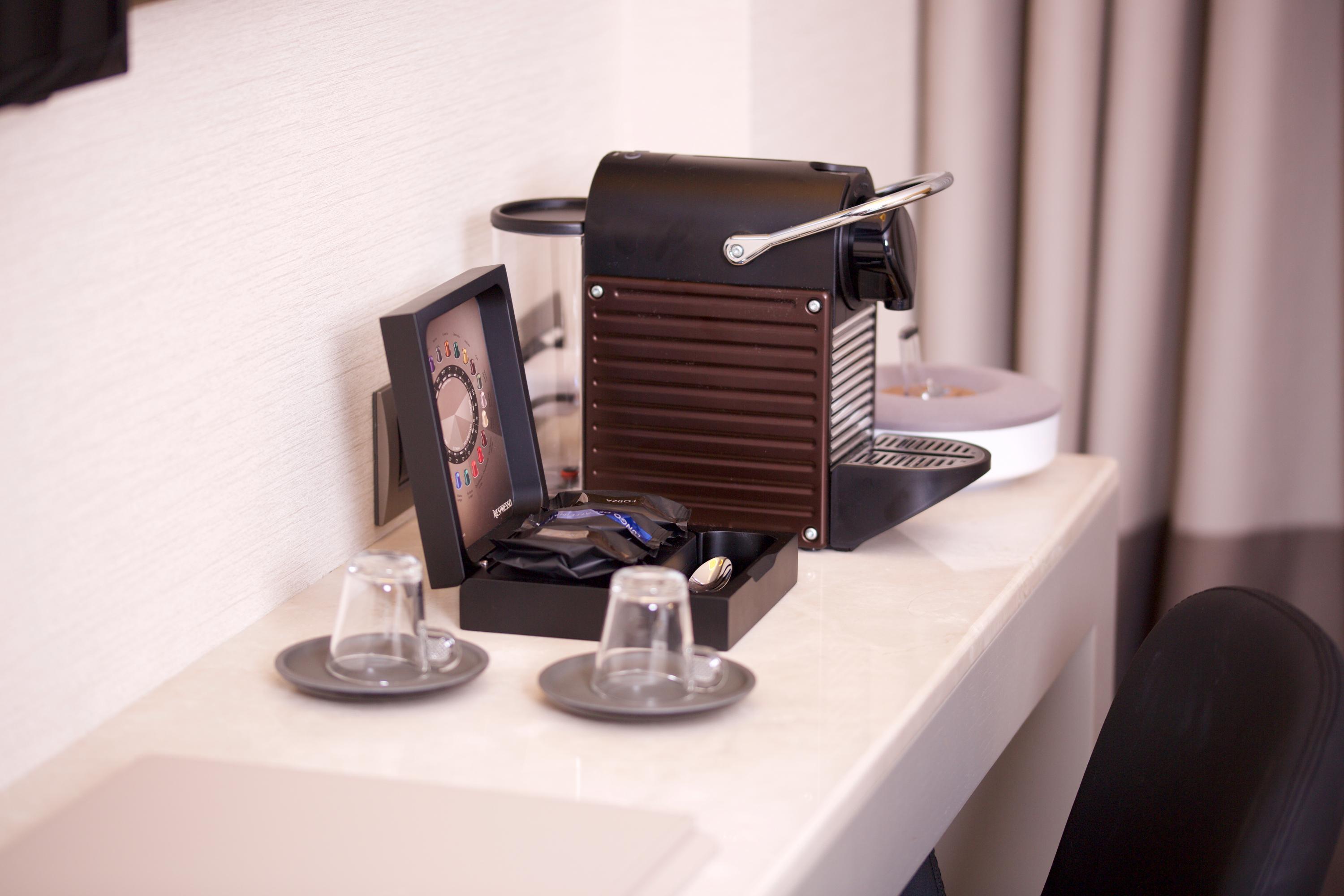 ดอสโซ่ ดอสซี่ โฮเต็ล แอน์ สปา ดาวน์ทาวน์ Hotel อิสตันบูล ภายนอก รูปภาพ The photo shows a coffee machine placed on a light-colored countertop. The machine appears to be a Nespresso-style espresso maker, featuring a sleek, modern design in black. Next to the machine, there is a small decorative box containing coffee pods.