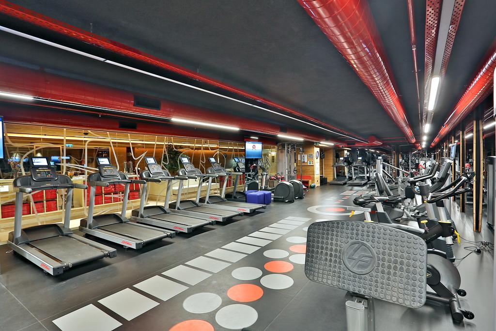 ดอสโซ่ ดอสซี่ โฮเต็ล แอน์ สปา ดาวน์ทาวน์ Hotel อิสตันบูล ภายนอก รูปภาพ The photo shows a modern fitness gym featuring various exercise equipment. On one side, there are several treadmills lined up, facing a screen, likely for entertainment or workout tracking. The flooring has a unique design with colorful circles, and 
