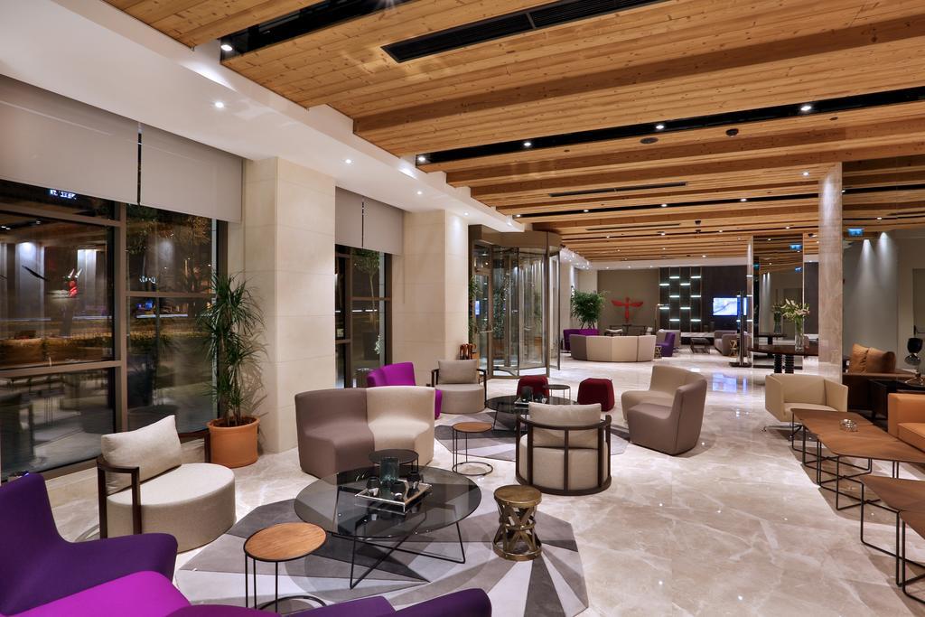 ดอสโซ่ ดอสซี่ โฮเต็ล แอน์ สปา ดาวน์ทาวน์ Hotel อิสตันบูล ภายนอก รูปภาพ The photo shows a modern and stylish lobby or lounge area. It features a combination of comfortable seating options, including a mix of chairs and sofas in various shapes and colors, such as purple and beige. The space is well-lit with natural light 